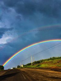 Scenic view of rainbow over road against sky