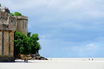 Scenic view of beach against cloudy sky