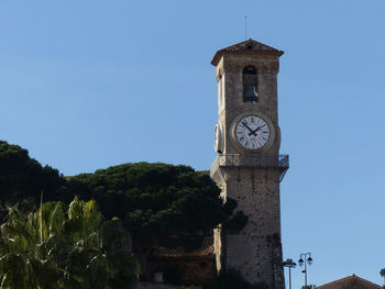 Low angle view of clock tower against blue sky