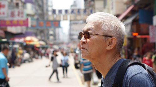 Portrait of man looking away on street in city