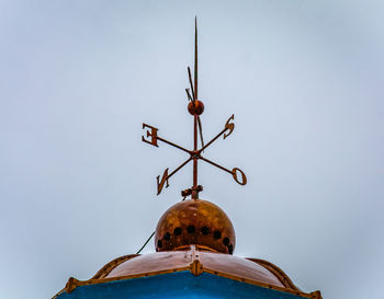 Low angle view of weather vane against clear sky