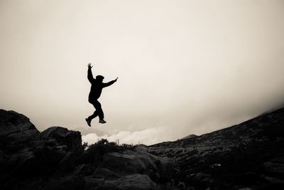 Low angle view of girl jumping in sky