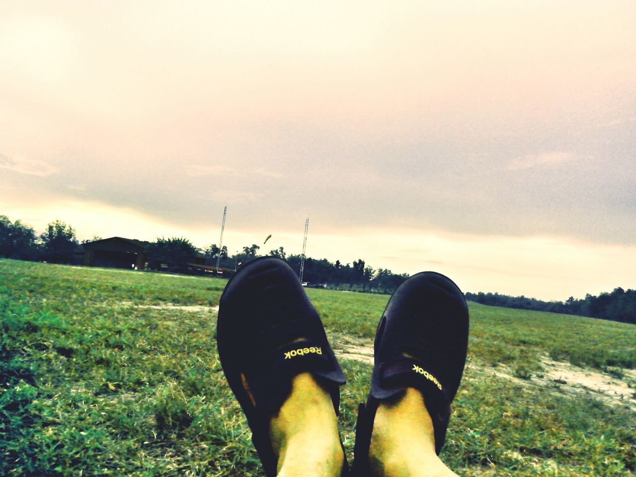 personal perspective, low section, person, shoe, grass, lifestyles, field, leisure activity, standing, sky, footwear, men, grassy, unrecognizable person, human foot, landscape, cloud - sky