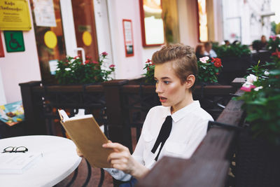 Portrait of smiling young woman using digital tablet while sitting at home