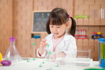 Girl holding ice cream on table