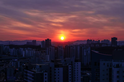 Modern buildings against sky during sunset