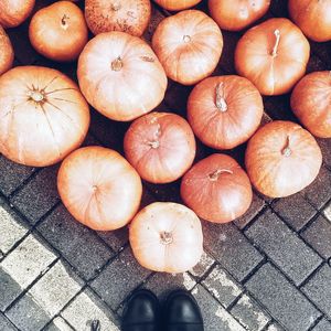 Low section of person standing by pumpkins