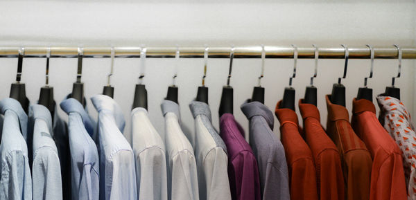 Close-up of colorful clothes hanging on rack at store
