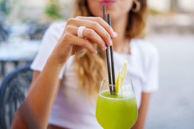 Midsection of woman holding drinking straw