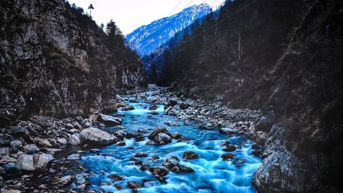 Aerial view of river amidst snow covered mountains