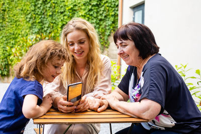 Women looking at camera while sitting on mobile phone