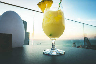 Glass of fruit on table against sky