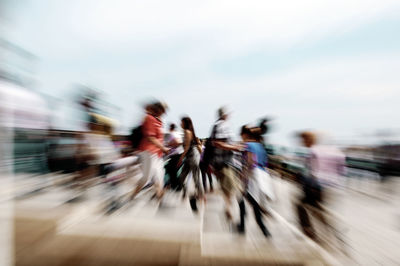 Blurred motion of people walking on road in city