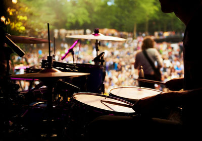 Midsection of man playing drum