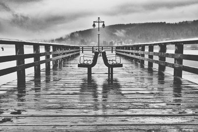 Pier on footbridge against sky