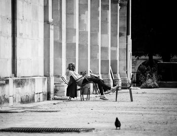 Side view of man sitting on chair