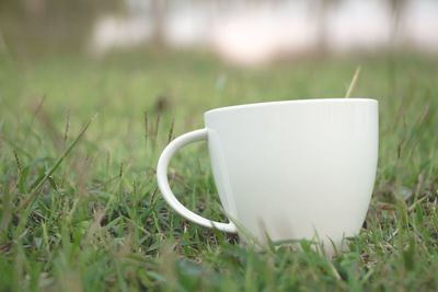 Close-up of coffee cup on grass