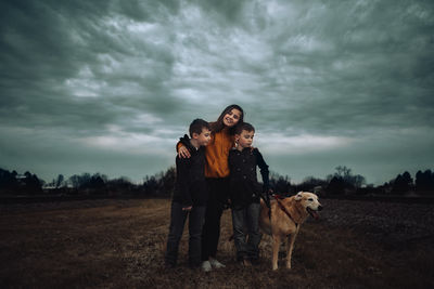 Dog standing in a field with siblings