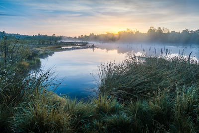 Scenic view of lake against sky at sunset