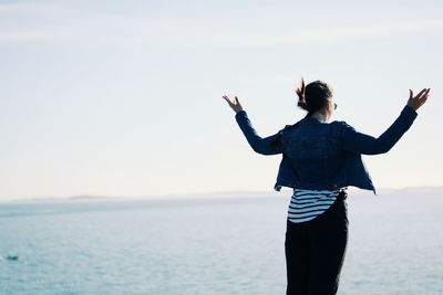 Rear view of man looking at sea against sky