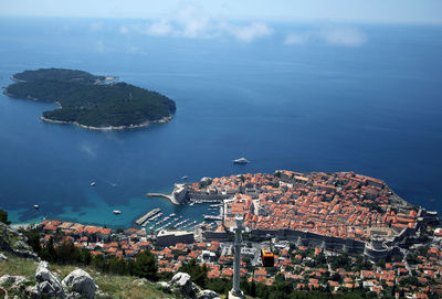 High angle view of city by sea against sky