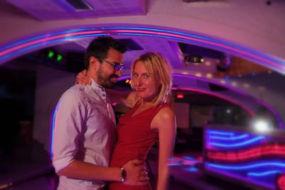 Young couple standing at illuminated music concert