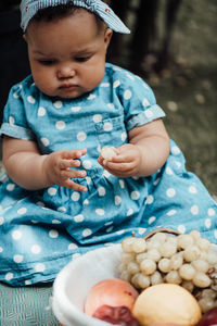 Midsection of man holding baby while sitting outdoors