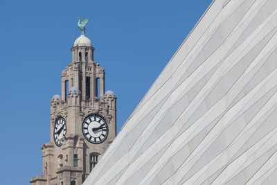 Low angle view of clock tower against clear blue sky