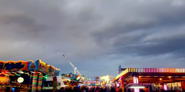 Low angle view of illuminated amusement park at night