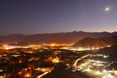 High angle view of illuminated city against sky at night