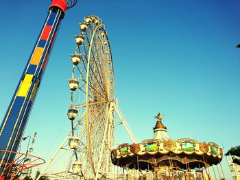 Low angle view of ferris wheel against blue sky