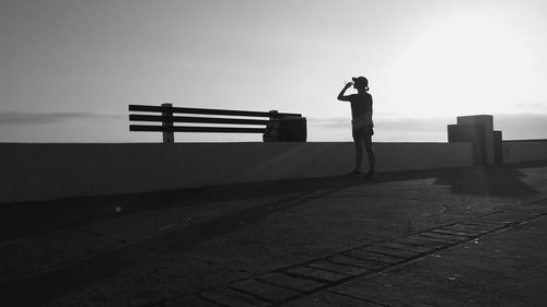 Man with umbrella standing against sky