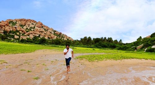 Full length of man running on field against landscape