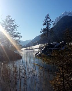 Scenic view of lake by mountains against clear sky