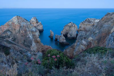 Panoramic view of rocks and sea against sky