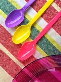 High angle view of multi colored plastic spoons on table