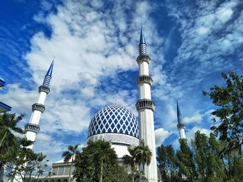 Low angle view of buildings against cloudy sky