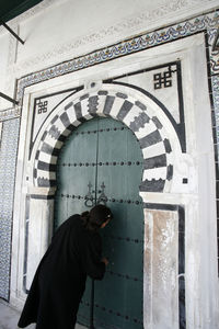 Woman standing by door of building