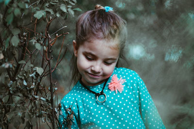 Close-up of smiling girl standing by plants