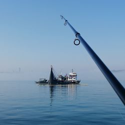 Sailboat in sea against clear sky
