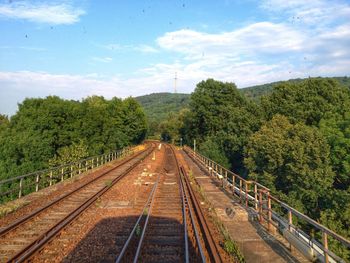 Railroad track against cloudy sky