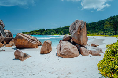 Rocks on shore by sea against sky