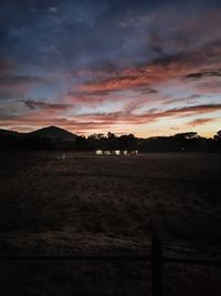 Scenic view of silhouette field against sky during sunset