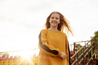 Young woman standing against sky