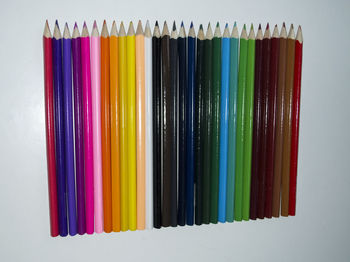 Close-up of colored pencils over white background