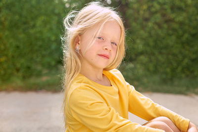 Portrait of young woman standing against plants