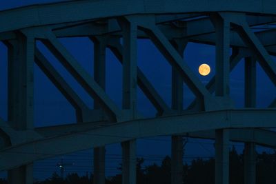 Low angle view of illuminated bridge against sky at night