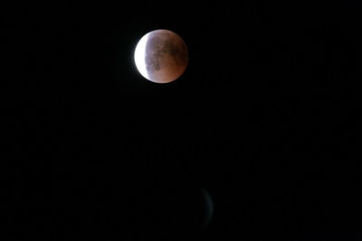 Low angle view of moon against dark sky