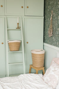 The interior of the bedroom is in the scandinavian style. mint cupboard by the bed and laundry 