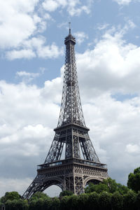 Photography of the eiffel tower of paris, france, standing alone over the tree, in a sunny sky